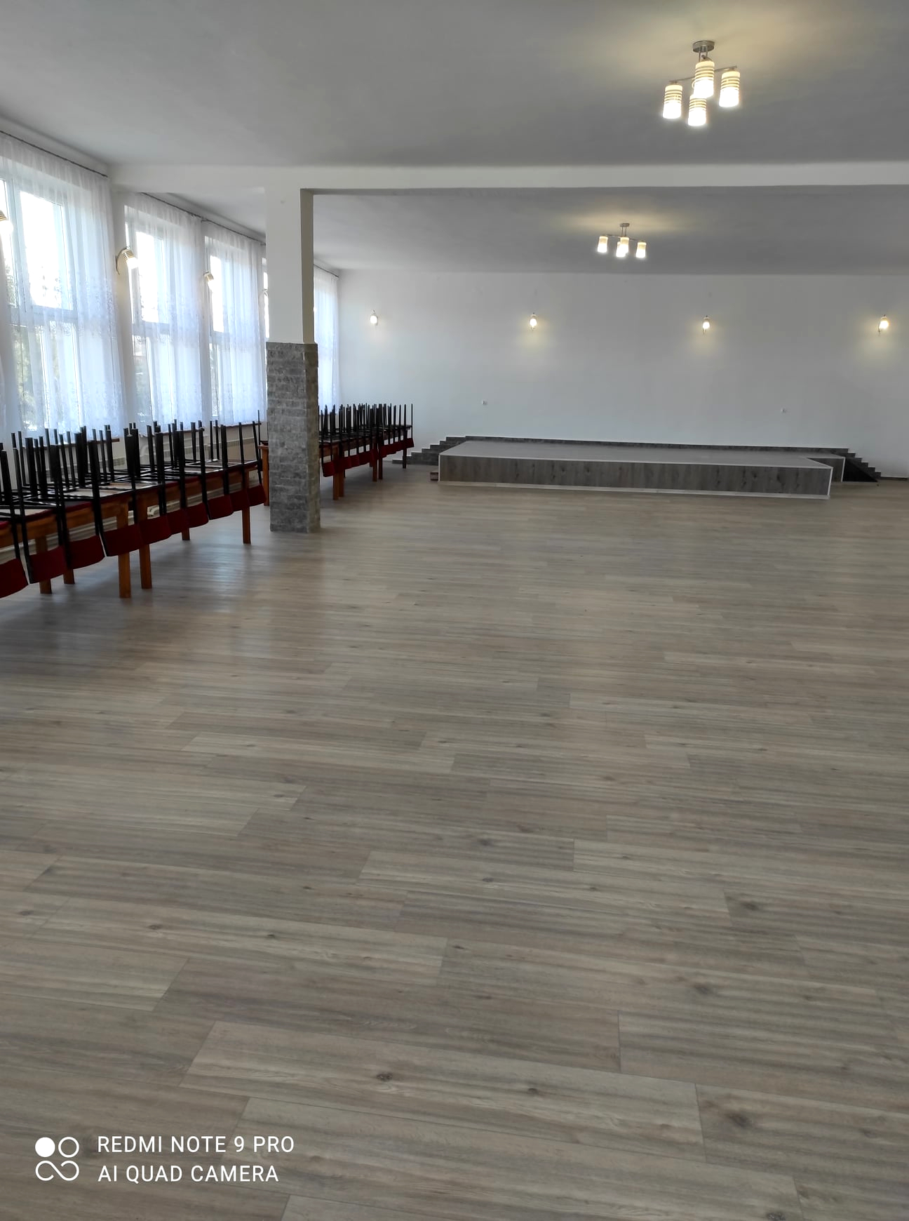 Zdjęcie sali w Domu Strażaka w Grabownicy Starzeńskiej po remoncie, nowe panele podłogowe, karnisze firany, kinkiet i żyrandol